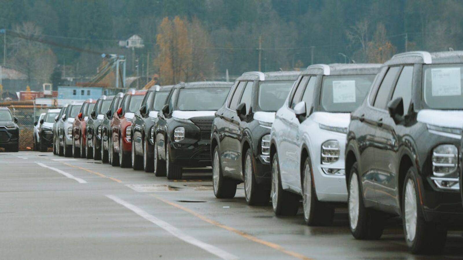 Кейс: продажа тягача с пробегом в Санкт-Петербурге — A line of new SUVs parked in an outdoor dealership lot, ready for sale.