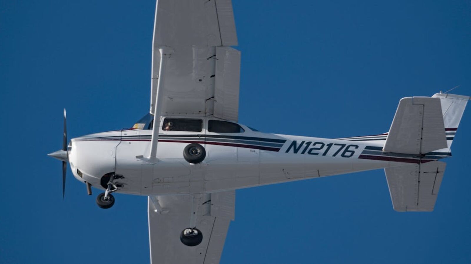 Кейс: продажа объекта малой авиации в Санкт-Петербурге — High-angle view of a private airplane soaring in a clear blue sky, showcasing aviation and freedom.