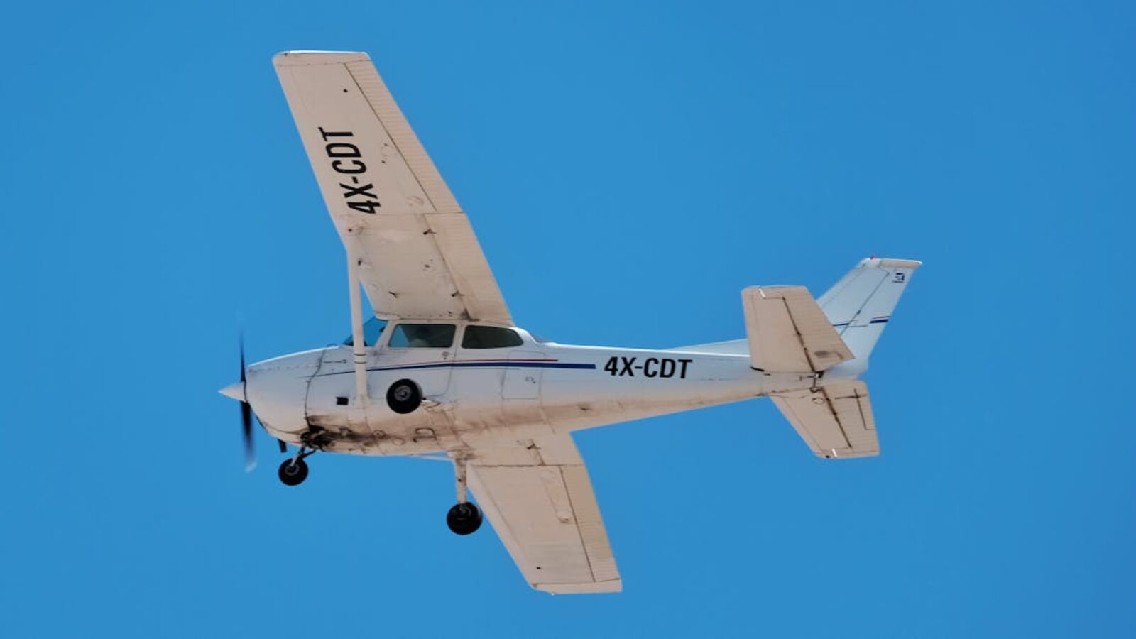 Выкуп лёгких самолётов в Санкт-Петербурге — A vintage propeller airplane flying high against a clear blue sky, illustrating freedom and aviation technology.