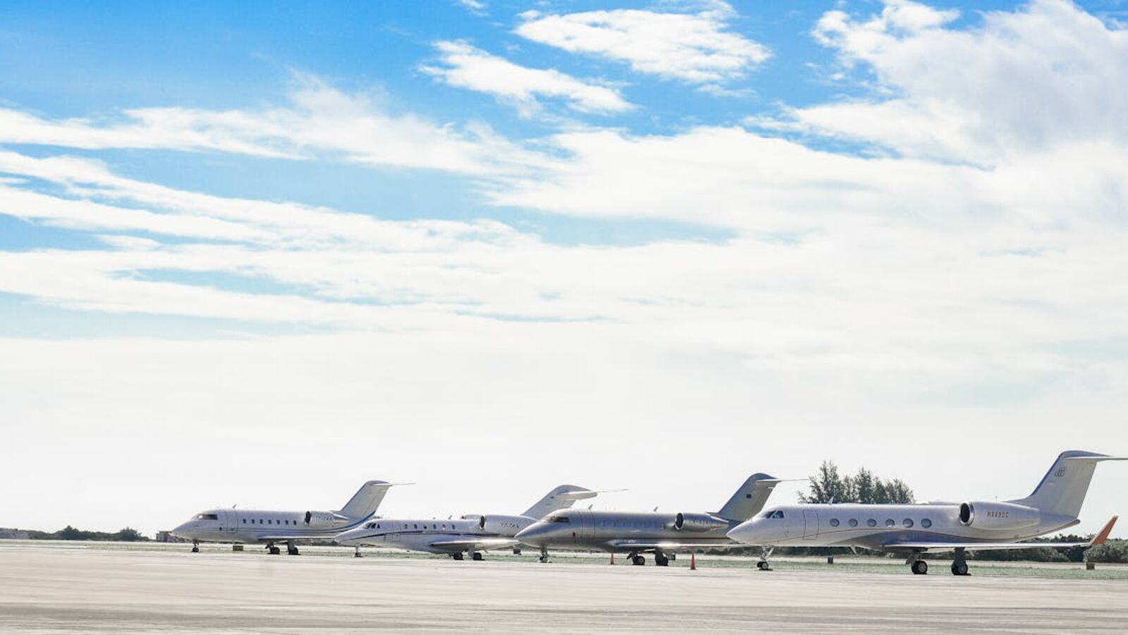 Кейс: продажа частного самолёта с узким рынком в Санкт-Петербурге — Row of private jets parked on a clear day at an open runway, showcasing aviation and luxury travel.