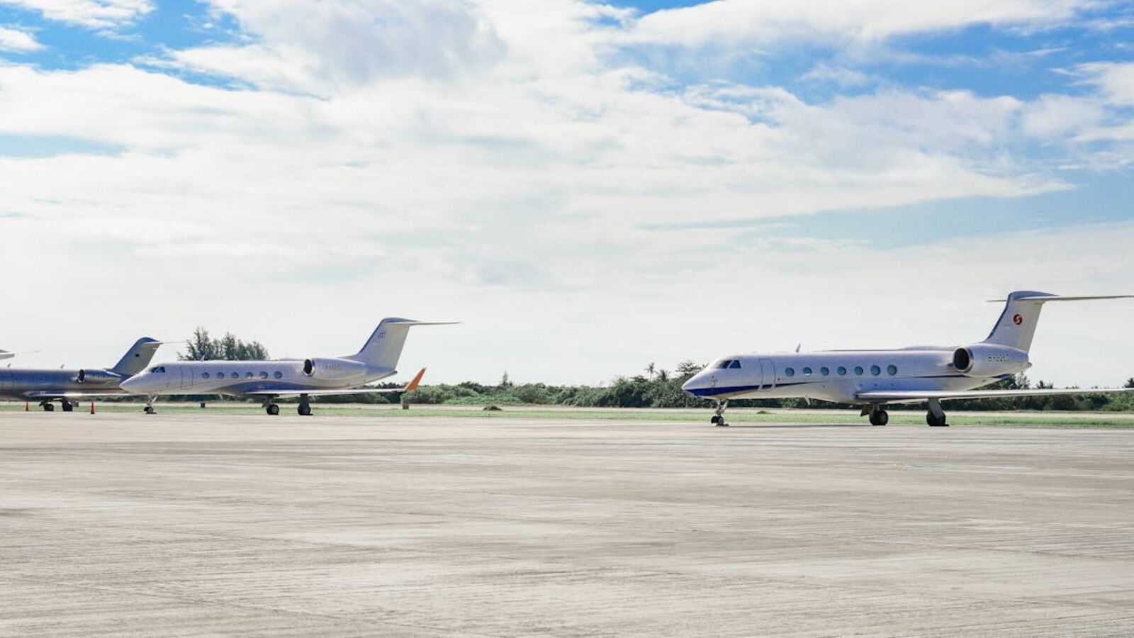 Выкуп турбовинтовых самолётов в Санкт-Петербурге — Private jets parked on an airport runway under a clear sky, highlighting luxury travel.