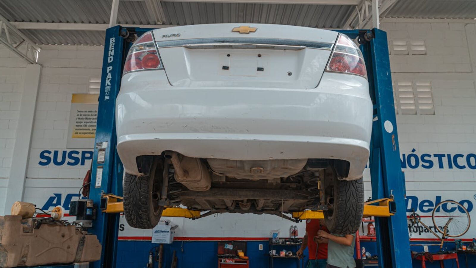 Кейс: продажа автосервиса после банкротства в Санкт-Петербурге — A white Chevrolet car is lifted for maintenance in an automotive repair shop.