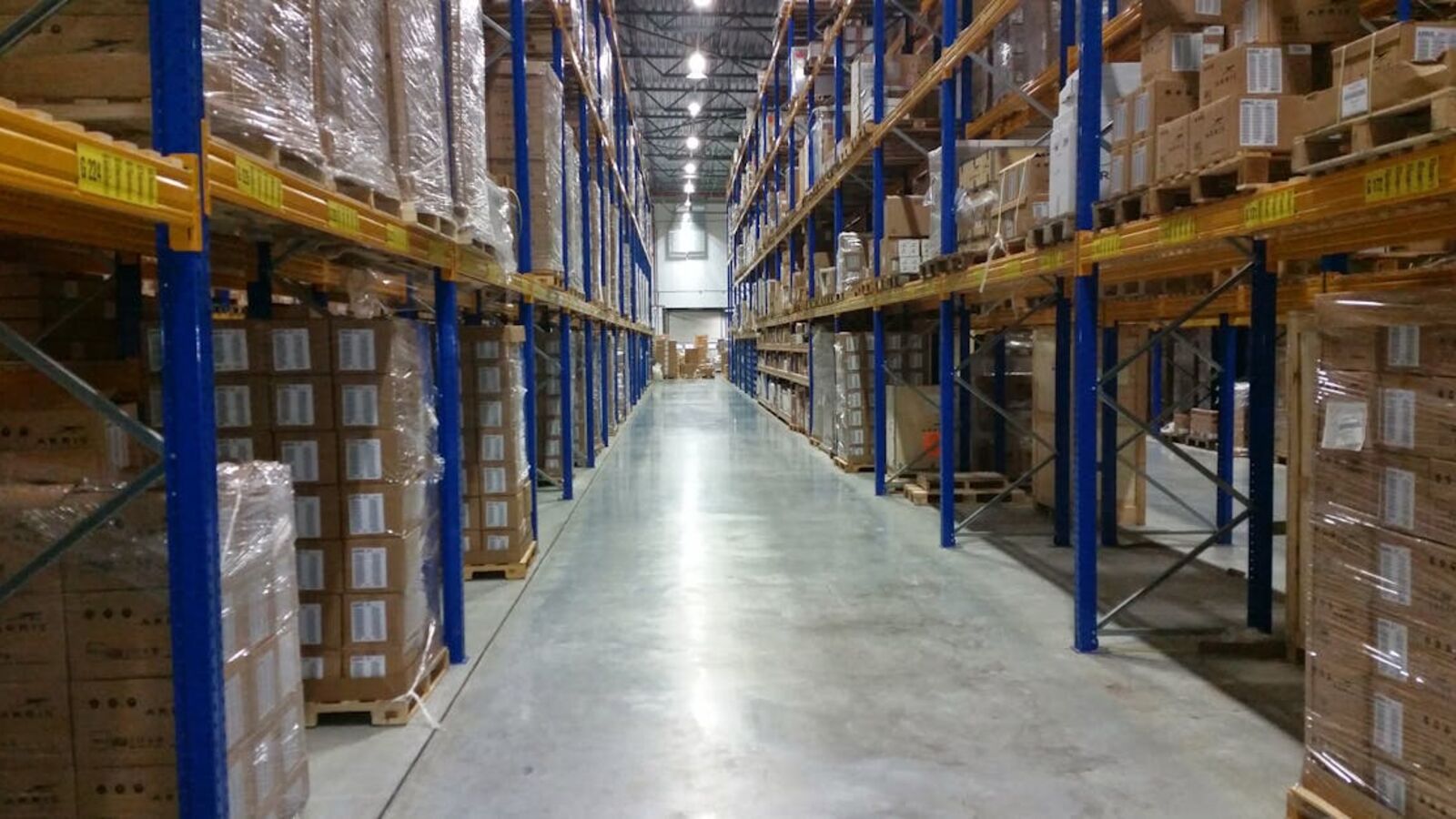 Кейс: продажа холодильного оборудования ресторана в Санкт-Петербурге — Interior view of a large warehouse aisle lined with stacks of organized cardboard boxes.