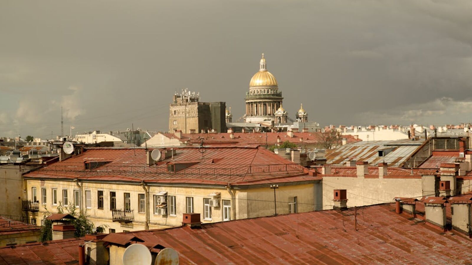 Кейс: продажа ипотечной квартиры в Санкт-Петербурге — View of St. Petersburg rooftops with St. Isaac's Cathedral under a stormy sky.