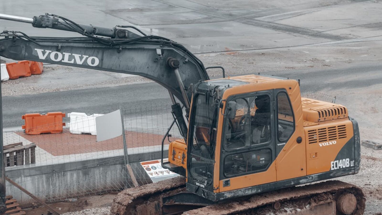 Кейс: продажа экскаватора Komatsu после стройки в Санкт-Петербурге — A yellow Volvo excavator at a construction site with muddy tracks.