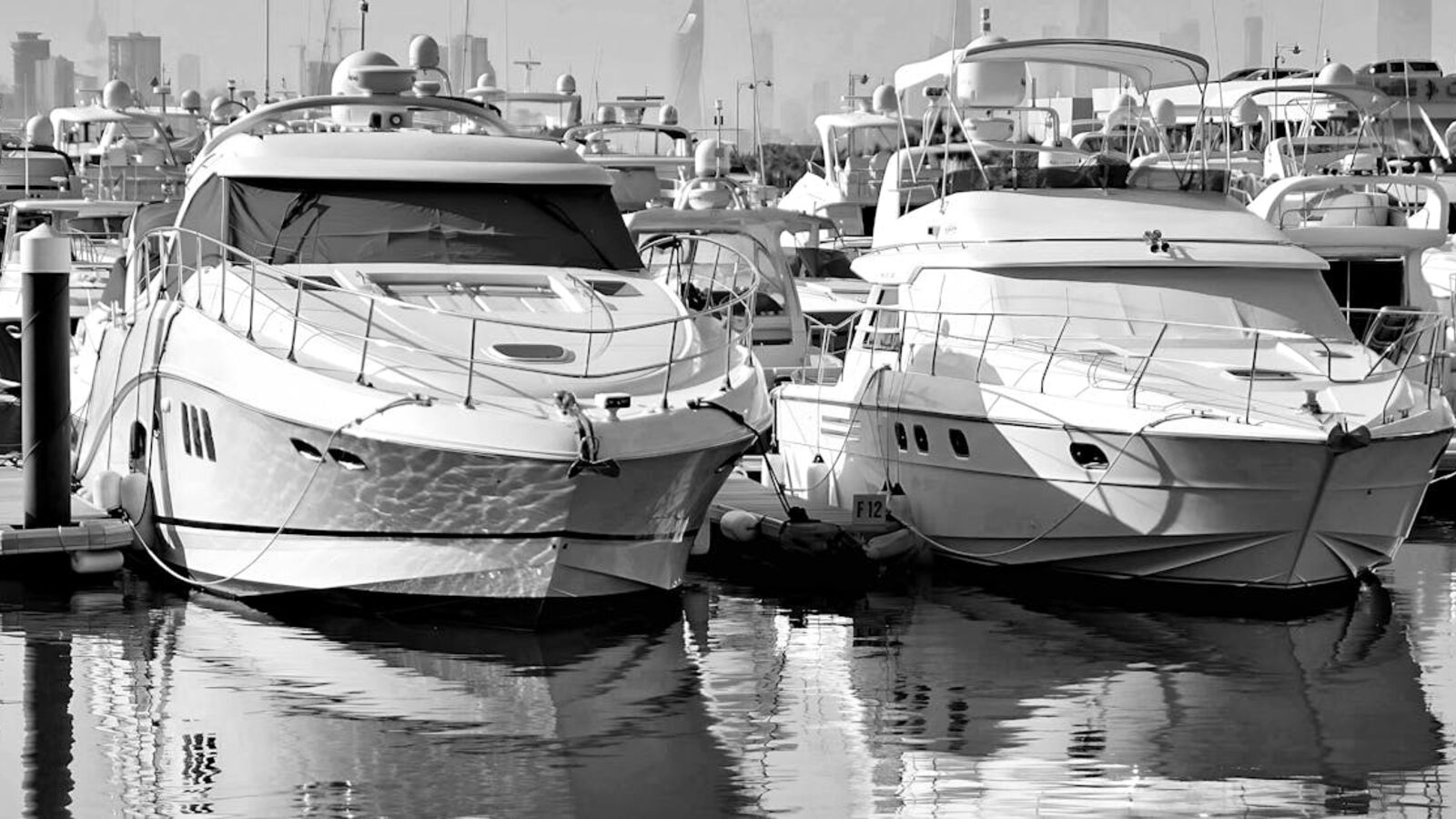 Кейс: продажа хаусбота со сложным спросом в Санкт-Петербурге — Elegant luxury yachts docked in an urban marina with cityscape backdrop.